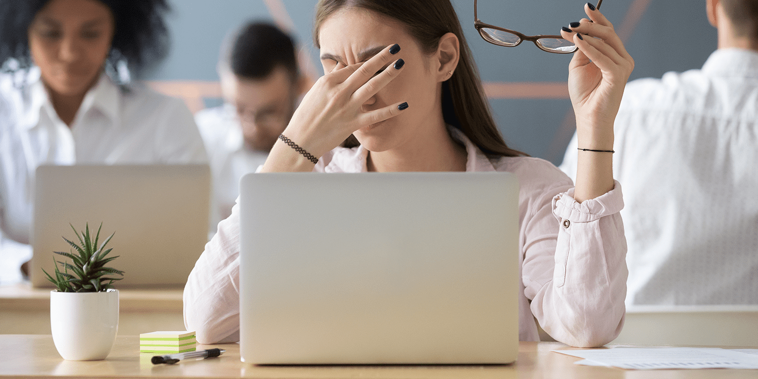 Image of a woman sitting in front of a laptop with her hand on her face, illustrating the frustration of a lost certificate of incorporation.