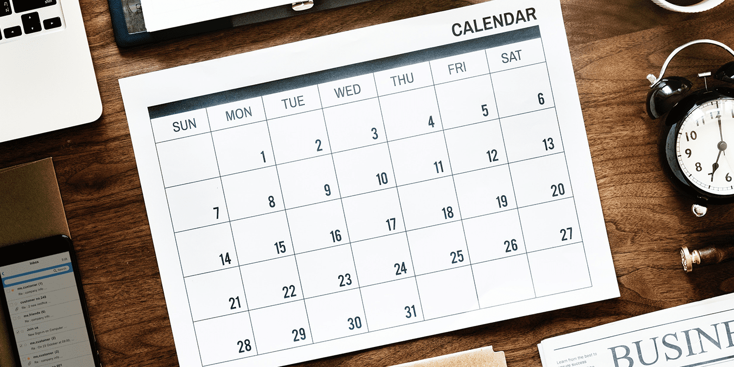 Photograph of a calendar, alarm clock, and other business equipment lying on a desk, illustrating the requirement to remember a company's accounting reference date.