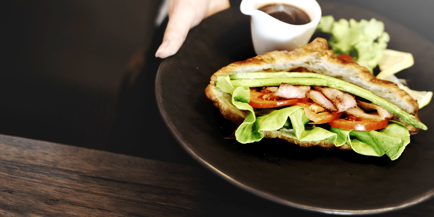 Photograph of a deli sandwich and side salad on a plate, illustrating the idea of opening a sandwich shop.