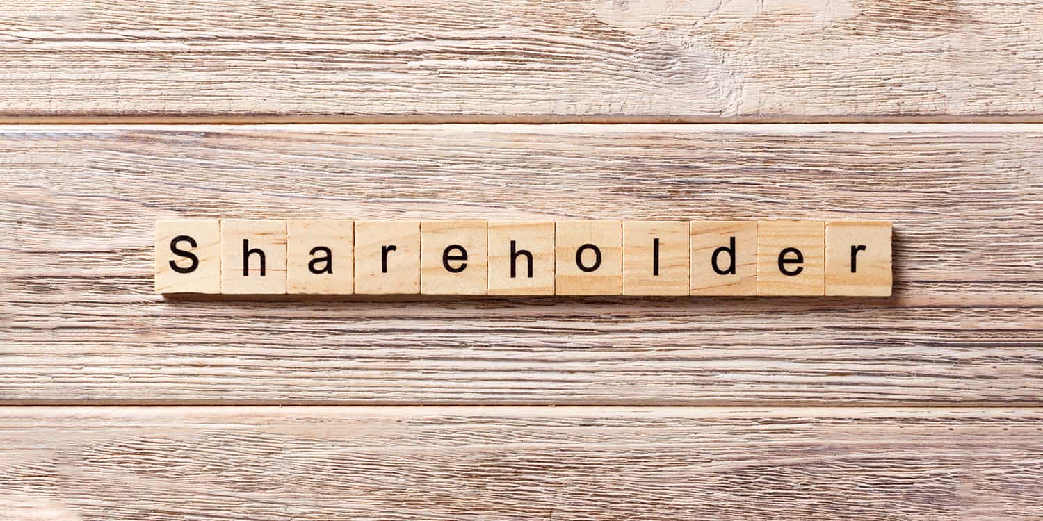 A row of small wooden tiles spelling the word "shareholder".