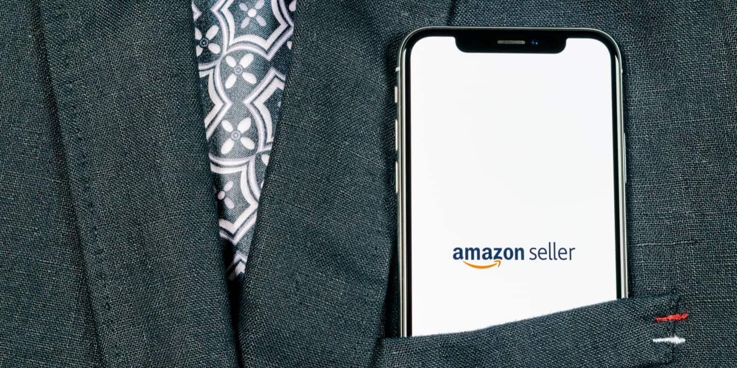 Close-up of a mobile phone protruding from the chest pocket of a suit jacket, with "Amazon seller" displayed on the screen, illustrating the concept of choosing to sell on Amazon.