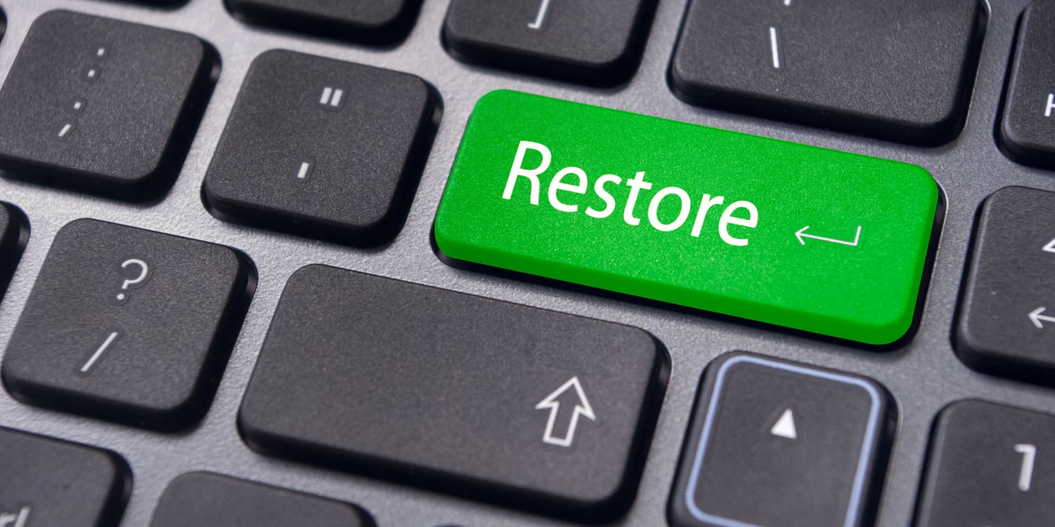 A close up of a laptop keyboard with one green key labelled 'Restore', representing the concept of applying to restore a company