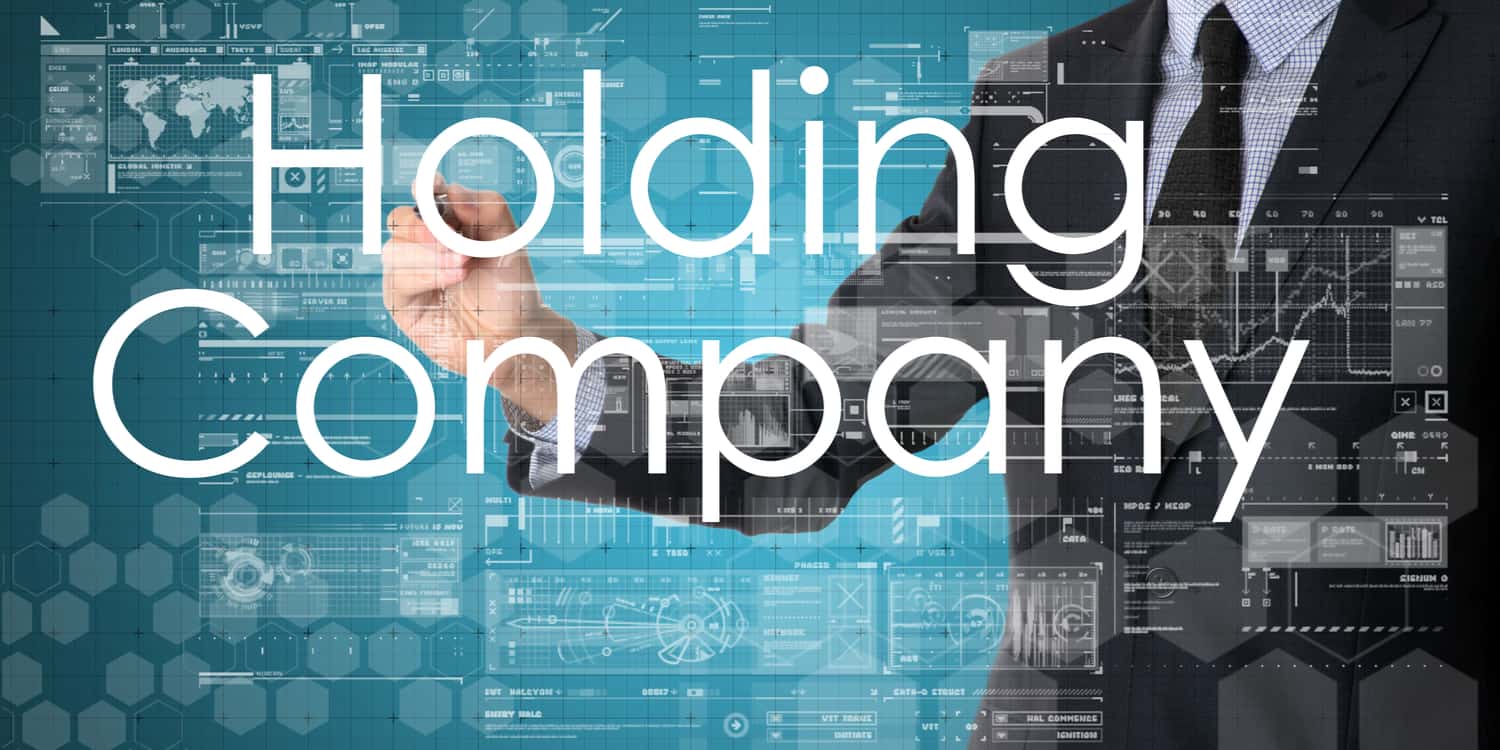 Business person working on full-size interactive screen with the words "Holding Company" displayed.