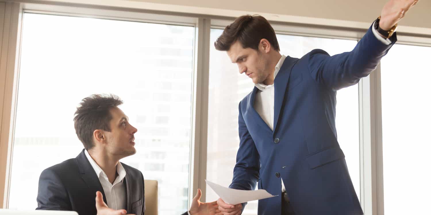 Image of two men in suits, one of whom is gesturing with an outstretched arm, illustrating the concept of removing a director from a limited company.