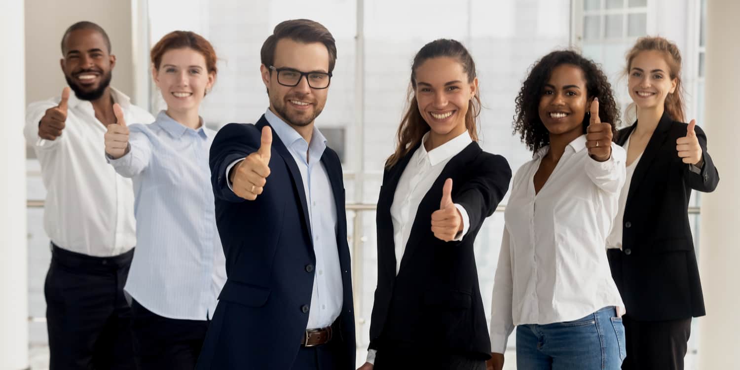 Company formation agent employee group showing thumbs up looking at camera - a happy professional multicultural team, recommending their professional services.