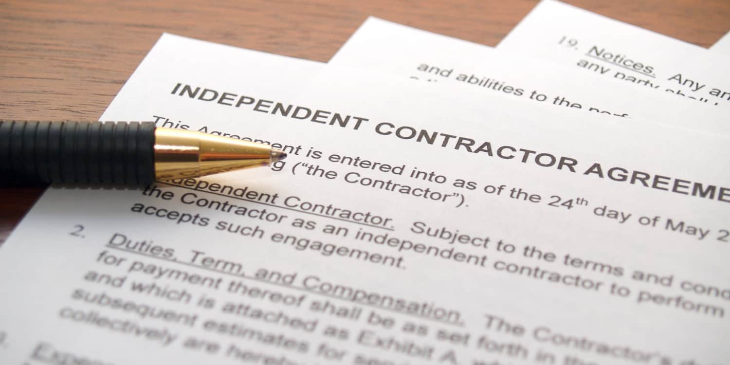 Independent Contractor Agreement lying on desktop with pen.