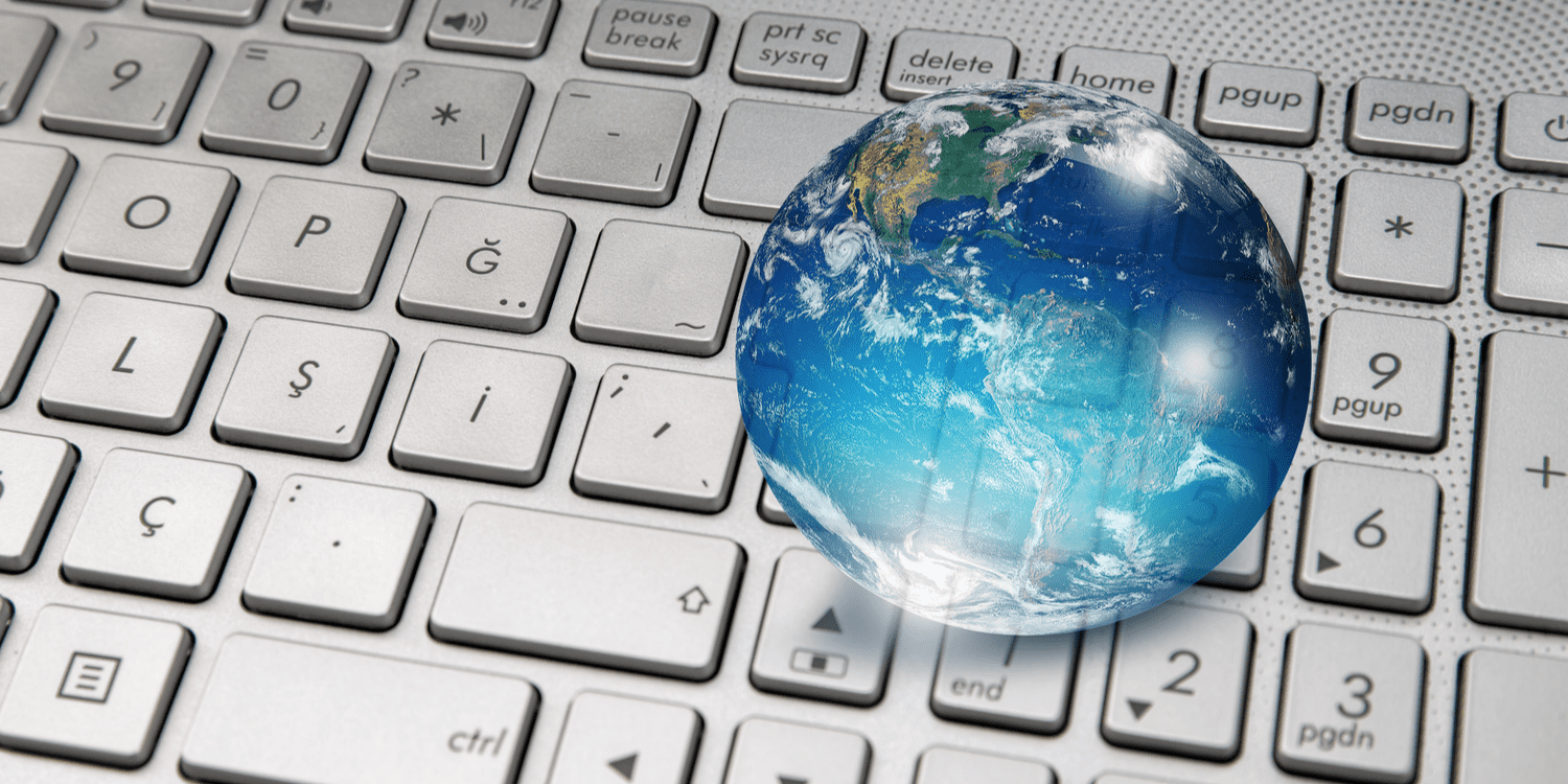 A glass globe sitting on top of a keyboard, demonstrating the concept of global business.