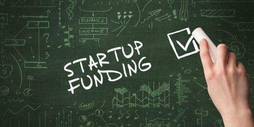 Hand drawing STARTUP FUNDING inscription with white chalk on blackboard,.