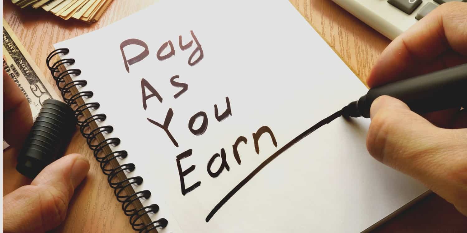 'Pay as you earn' written on a pad of paper illustrating the PAYE concept.