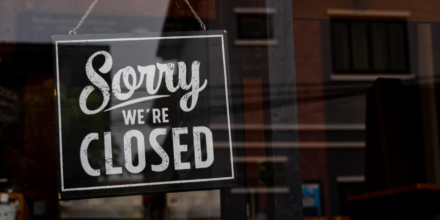 Vintage black and white retro 'Sorry We're Closed' sign on a coffee glass door.