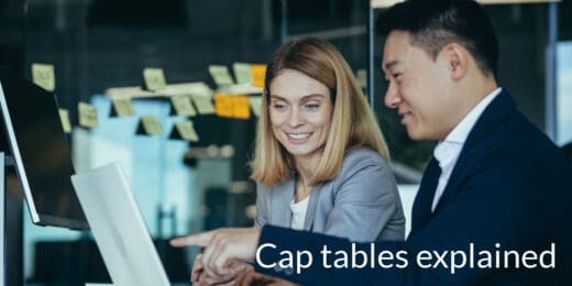 Male colleague explaining cap tables to a young female colleague.