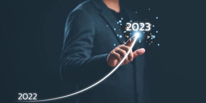 Businessman hand drawing line for increasing arrow from 2022 to 2023 illustrating the increase in company formations concept.