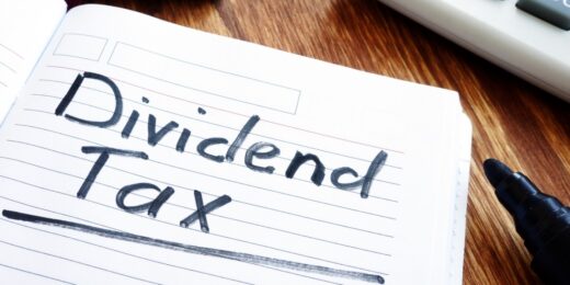 Notebook page with “Dividend Tax” handwritten in black marker, next to a calculator.