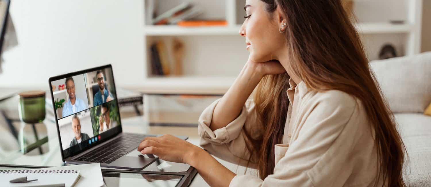 An employee practicing flexible working by sitting in front of her laptop in her home office, in a virtual meeting