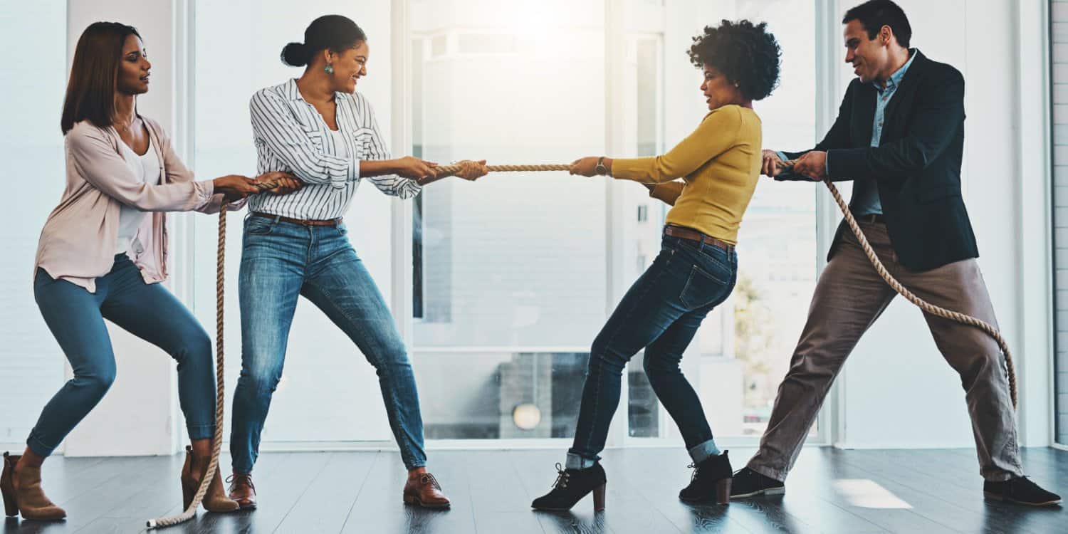 Concept of shareholder deadlock. Shot of a group of businesspeople pulling on a rope during a tug of war in an office.