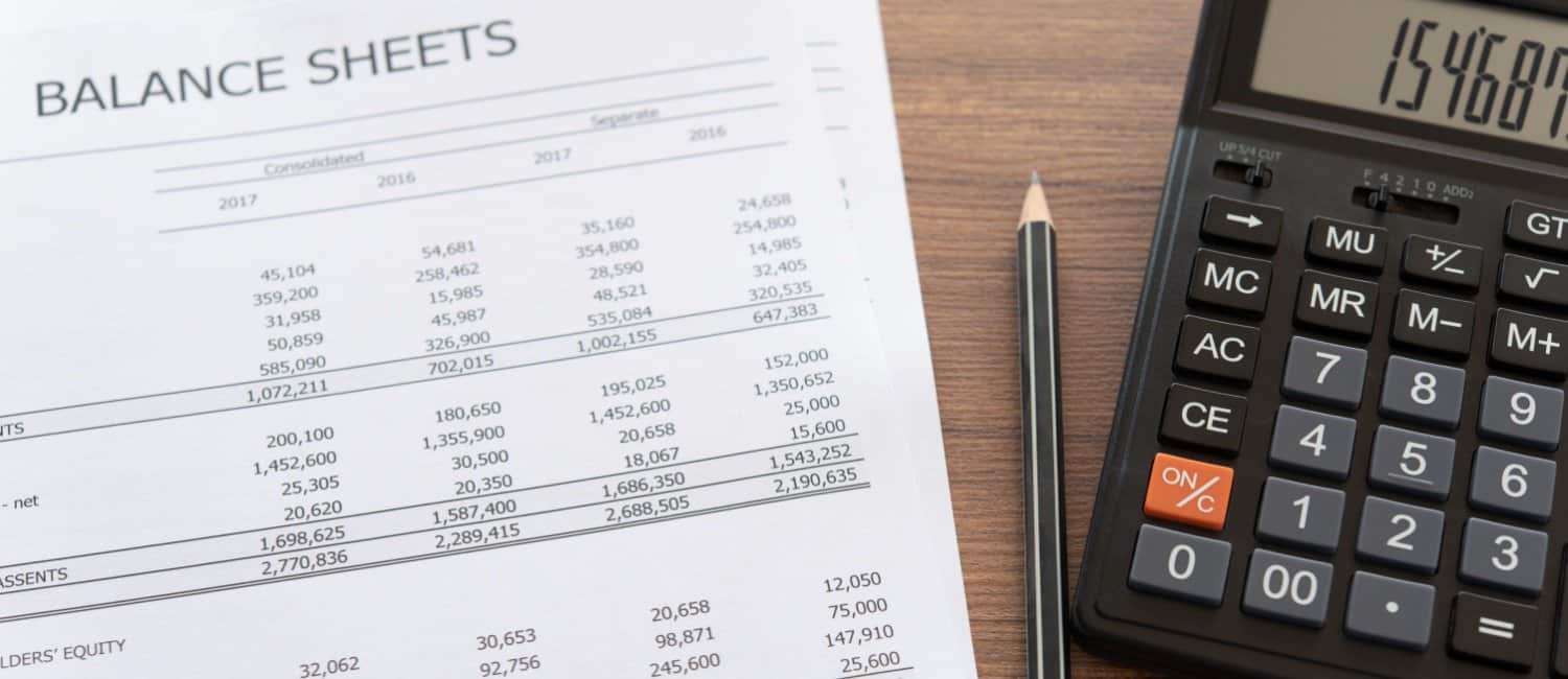 Above view of balance sheet report for micro-entity annual accounts with pencil and calculator on desk