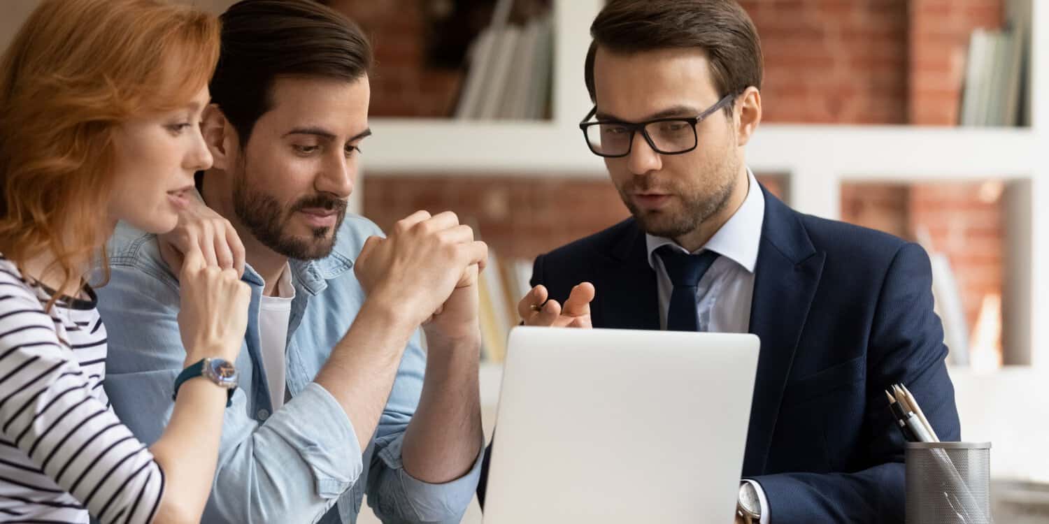 Male company expert in business suit consulting with a married couple at their home on how to remove a residential address from the Companies House register.