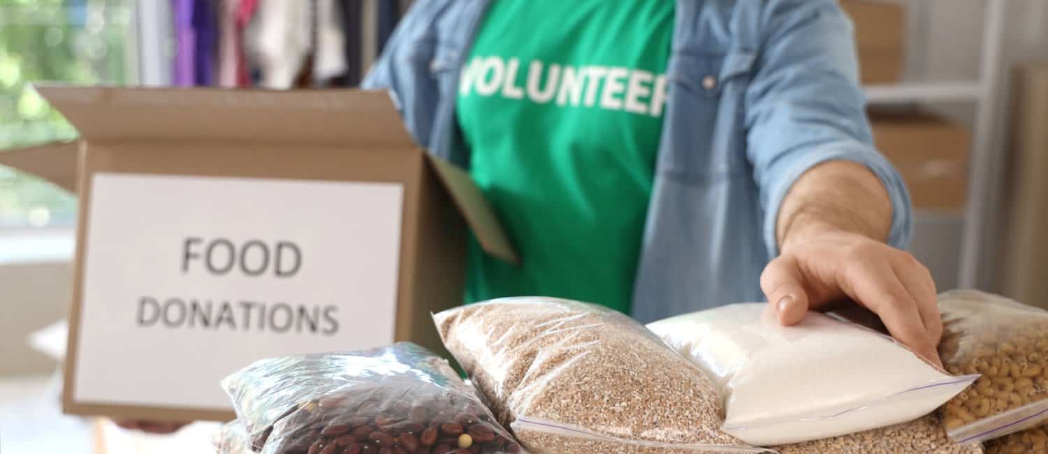 An image of a volunteer arranging a box of food donations to reduce food waste