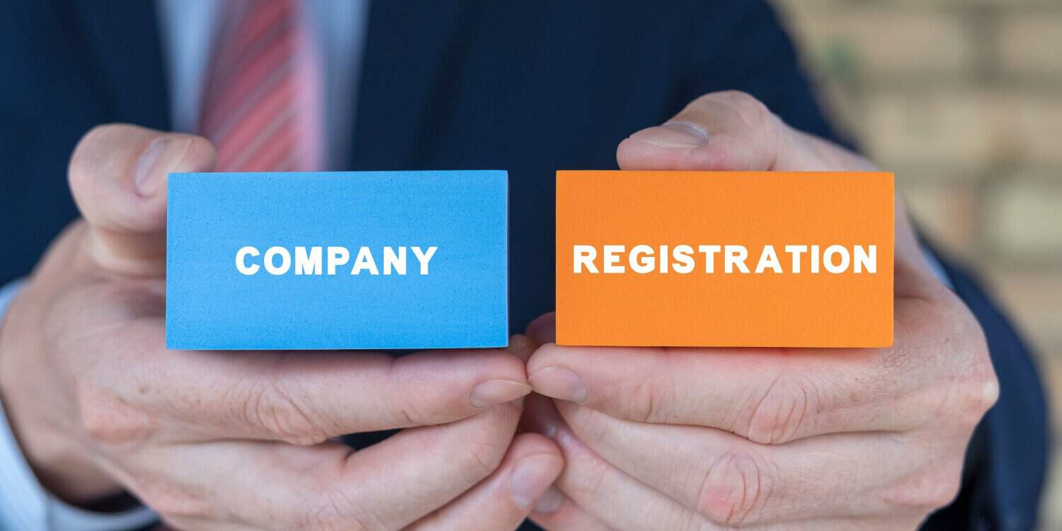 Businessman holding colourful blocks with inscription: COMPANY REGISTRATION. New company registration concept.
