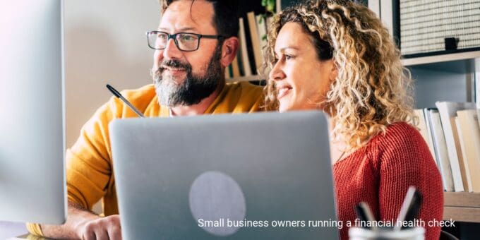 Small business owners working in a home office conducting a financial health check.