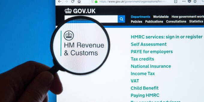 The HM Revenue & Customs website with hand and spy glass - concept of HMRC accessing bank acocunts.