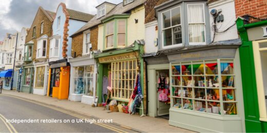 A UK high street with several independent retail stores. Each store is brightly coloured and decorated.