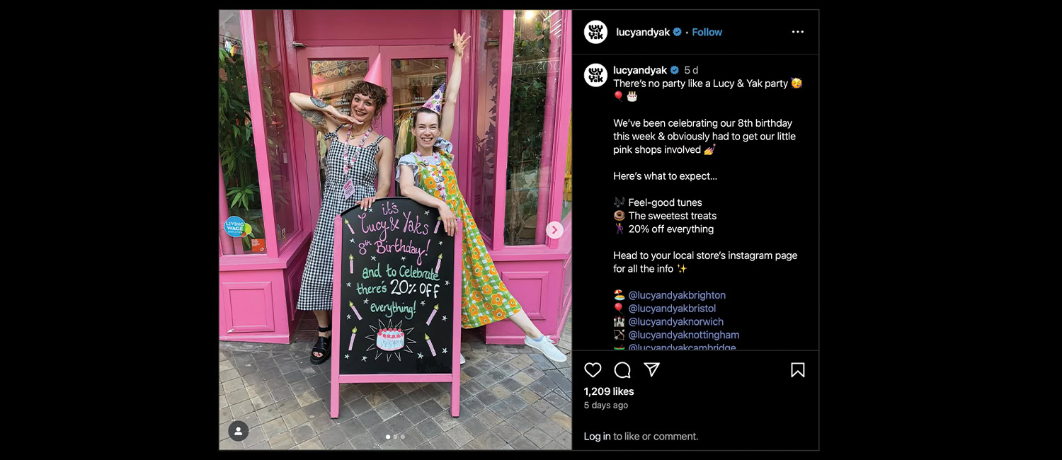 An Instagram screenshot featuring two women celebrating at a pink storefront, holding a sign for Lucy & Yak's 8th birthday sale with 20% off.