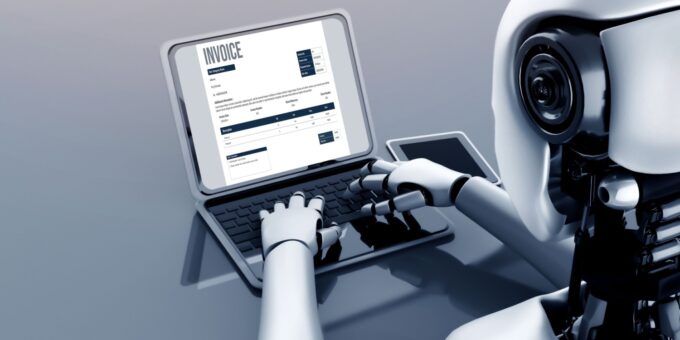 A humanoid robot demonstrates automation by typing on a laptop displaying an invoice, symbolising artificial intelligence in bookkeeping