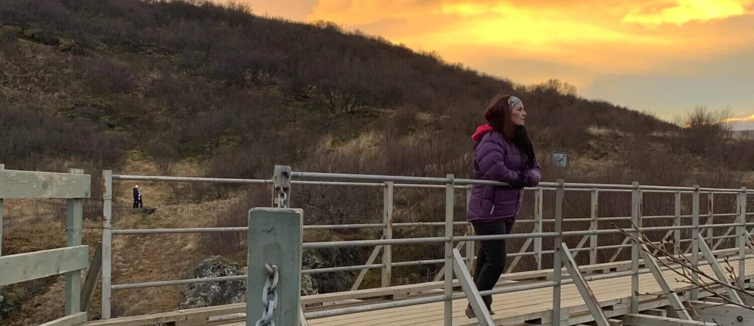 Louise Baverstock-Price standing and looking into the horizon with sunset background