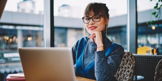 Female business owner working on email marketing strategy using a laptop in a modern café