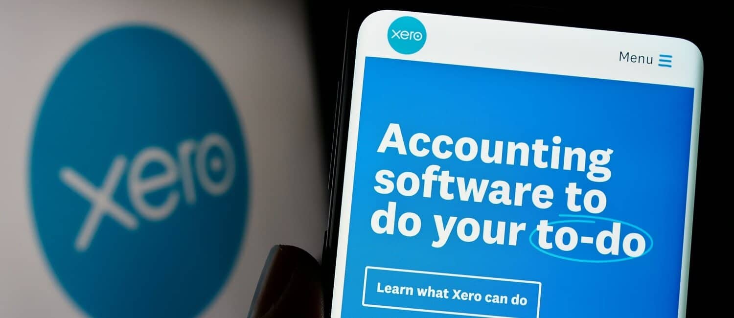 Person holding a smartphone with the Xero accounting app displayed on the screen.