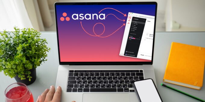 Laptop screen displaying Asana interface, used as marketing software to manage business projects, with office supplies and a plant on the desk