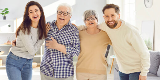 A group of 4 happy adult members smiling and looking at the camera.