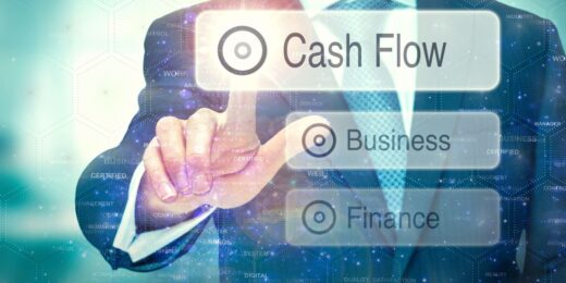 Three floating boxes that say finance, business, and cash flow within each. A an in a suit is pointing at the 'cash flow' box.
